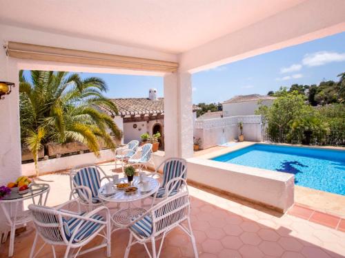 un patio avec une table et des chaises et une piscine dans l'établissement Holiday Home Casa Moser by Interhome, à Jávea