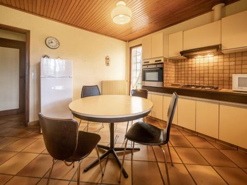 une cuisine avec une table, des chaises et un réfrigérateur dans l'établissement Holiday Home Maisouet by Interhome, à Mimizan