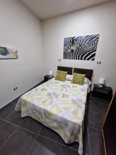 Vegueta Casa Los Girasoles في لاس بالماس دي غران كاناريا: غرفة نوم مع سرير وصورة حمار وحشري على الحائط
