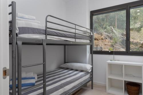 een kamer met 2 stapelbedden en een raam bij VILLA PUERTO RICO in Llafranc
