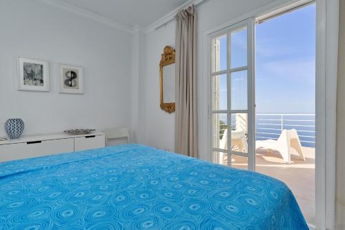 a bedroom with a bed and a sliding glass door at Casa Mariposa in Almuñécar