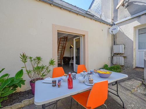 uma mesa branca com cadeiras laranjas num pátio em Holiday Home Maison Des Lilas by Interhome em Quiberon