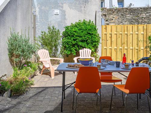 um pátio com uma mesa e cadeiras num pátio em Holiday Home Maison Des Lilas by Interhome em Quiberon