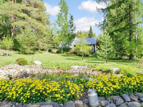 a garden with yellow flowers and a pond at Holiday Home Ateljee by Interhome in Rääkkylä