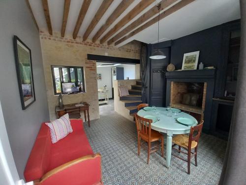 a living room with a table and a red couch at ACCROCHE-COEUR MAISON de PECHEUR in Trouville-sur-Mer