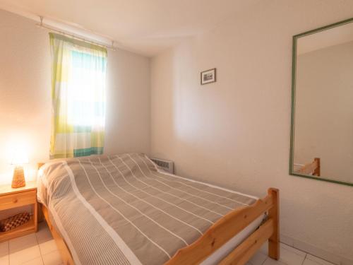 une chambre avec un lit, un miroir et une fenêtre dans l'établissement Apartment Les Terrasses du Lac-9 by Interhome, au Grau-du-Roi