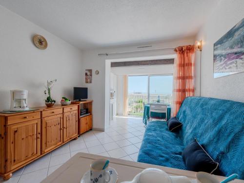 un salon avec un canapé bleu et une table dans l'établissement Apartment Aigues Marines by Interhome, à Port-Leucate
