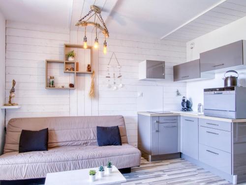 un salon avec un canapé et une cuisine dans l'établissement Apartment Les Aigues Marines-68 by Interhome, à Saint-Cyr-sur-Mer