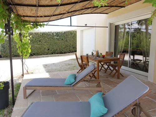een patio met een tafel en stoelen en een tafel en een tafelblad bij Apartment Le Vallon des Chenes by Interhome in Saint-Aygulf