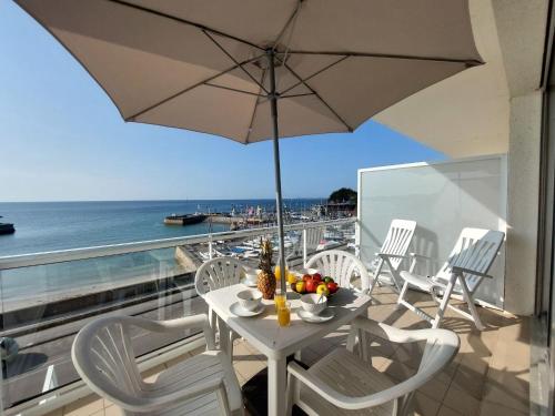 a table with an umbrella on a balcony with the ocean at Studio Atlantique-3 by Interhome in Carnac