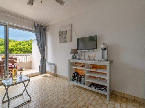 ein Wohnzimmer mit einem TV und einem Tisch in der Unterkunft Studio La Frégate-13 by Interhome in Le Grau-du-Roi