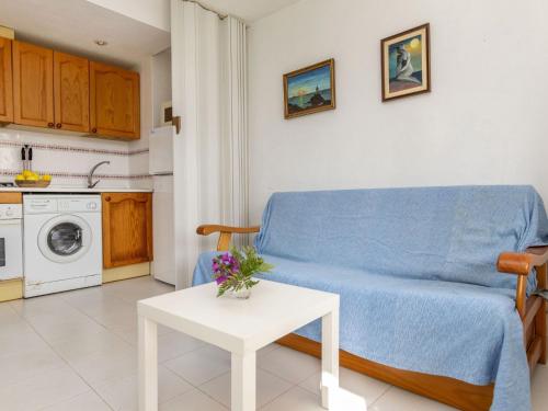 un salon avec un canapé bleu et une table dans l'établissement Apartment Cala Gabriel by Interhome, à Vinaròs