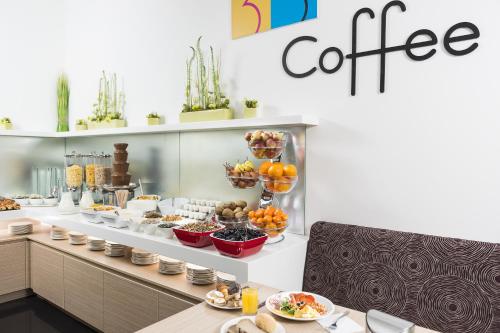 a buffet line with food on display in a restaurant at Bo33 Hotel Family & Suites in Budapest