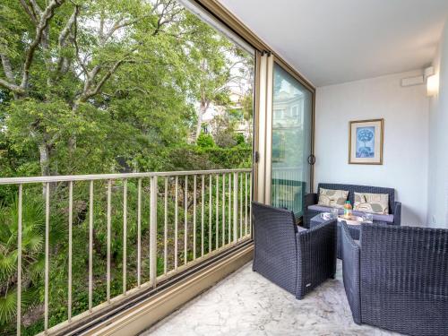 un balcon avec une table et des chaises et une grande fenêtre dans l'établissement Apartment Val Joli-1 by Interhome, à Cannes