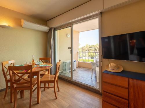 d'une salle à manger avec une table et une télévision à écran plat. dans l'établissement Studio Port de La Gavine-30 by Interhome, à Hyères