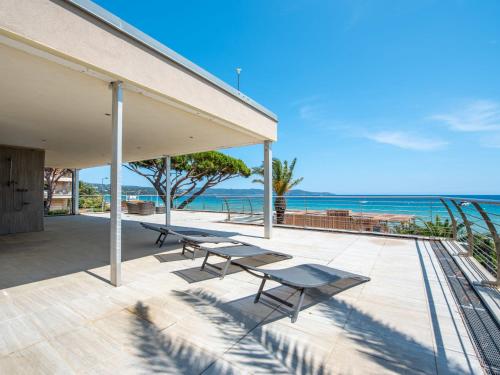 d'une terrasse avec bancs et vue sur l'océan en arrière-plan. dans l'établissement Villa Cabanon by Interhome, à Cavalaire-sur-Mer
