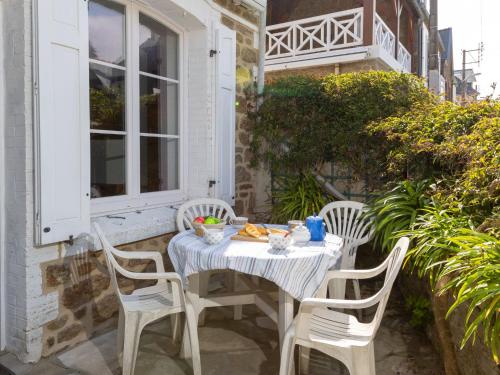 une table avec quatre chaises assises sur une terrasse dans l'établissement Holiday Home L'Eglantine by Interhome, à Saint-Malo