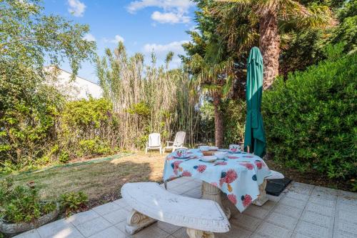d'une table, de deux chaises et d'une planche de surf sur une terrasse. dans l'établissement Maison Bergeronnette - Welkeys, à Saint-Georges-dʼOléron
