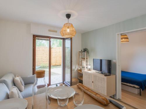un salon avec un canapé et une télévision dans l'établissement Apartment by Interhome, à Cabourg