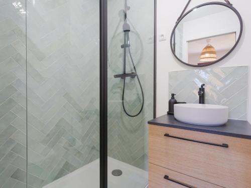 une salle de bain avec une douche avec un lavabo et un miroir dans l'établissement Apartment by Interhome, à Cabourg