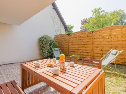 - une table en bois avec des boissons sur la terrasse dans l'établissement Apartment by Interhome, à Cabourg