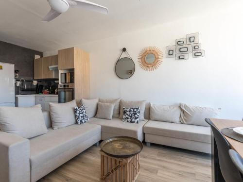 un salon avec un canapé et une table dans l'établissement Apartment Les Huniers by Interhome, au Grau-du-Roi