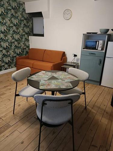 un salon avec une table, des chaises et un canapé dans l'établissement Charmante maison de ville Les 2B46, à Cahors