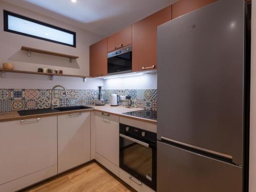 une cuisine avec des armoires blanches et un réfrigérateur en acier inoxydable dans l'établissement Apartment Christoph Colomb by Interhome, à Hyères