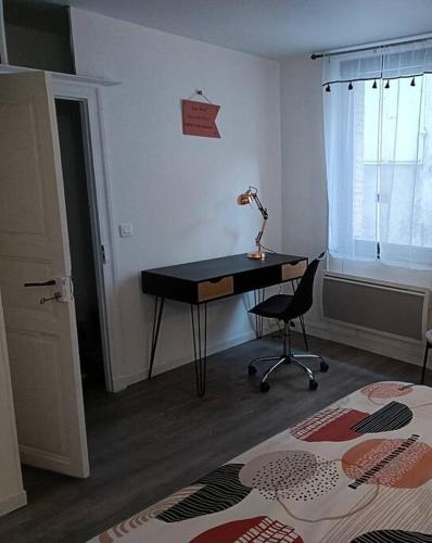 - une chambre avec un bureau et une lampe sur une table dans l'établissement Charmante maison de ville Les 2B46, à Cahors