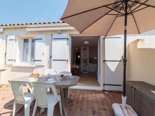 une table et des chaises avec un parasol sur une terrasse dans l'établissement Apartment Les Palatines by Interhome, à Saint-Palais-sur-Mer