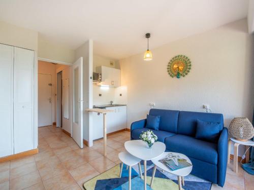 un salon avec un canapé bleu et une table dans l'établissement Studio de Cavalaire by Interhome, à Cavalaire-sur-Mer