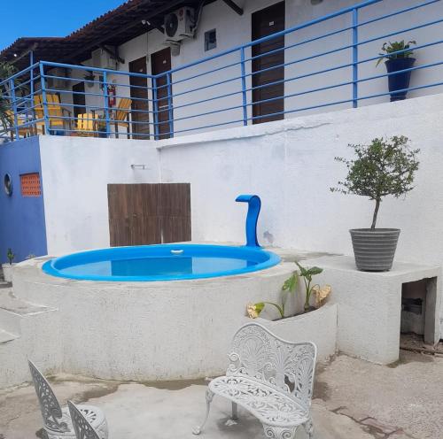 a swimming pool with a table and chairs and a building at Jampa Mar Pousada in João Pessoa