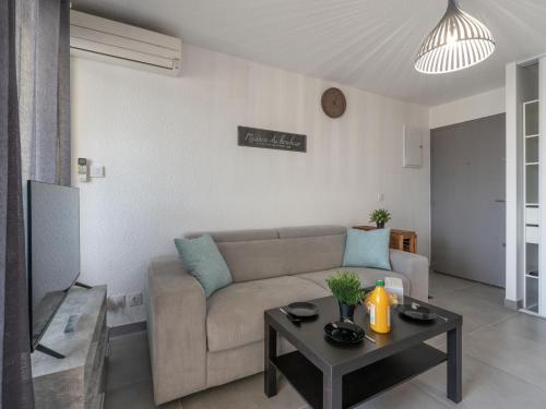 ein Wohnzimmer mit einem Sofa und einem Tisch in der Unterkunft Apartment Los Amigos-14 by Interhome in Le Grau-du-Roi
