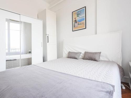 - une chambre blanche avec un lit blanc et un miroir dans l'établissement Apartment Les terrasses de l'Escurial by Interhome, à Nice