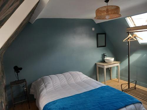 ein Schlafzimmer mit einer blauen Wand und einem Bett in der Unterkunft ACCROCHE-COEUR MAISON de PECHEUR in Trouville-sur-Mer