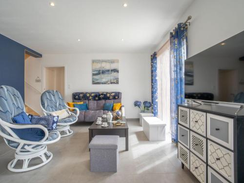 un salon avec des chaises bleues et un canapé dans l'établissement Holiday Home Les Agapanthes by Interhome, à Cléder
