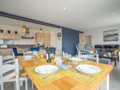 une salle à manger avec une table avec des assiettes et des verres à vin dans l'établissement Holiday Home Les Agapanthes by Interhome, à Cléder