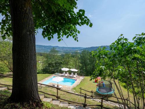 a backyard with a swimming pool and a tree at Apartment Casa Domenica by Interhome in Monastero Bormida