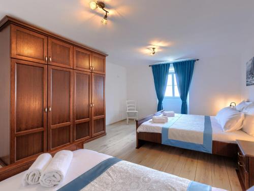 a bedroom with two beds and wooden cabinets and a window at Holiday Home Di Nelo by Interhome in Labin