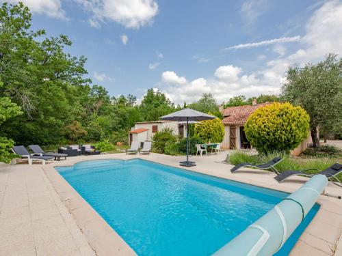 une piscine avec des chaises et une maison dans l'établissement Holiday Home Kerylou by Interhome, à Saint-Cézaire-sur-Siagne