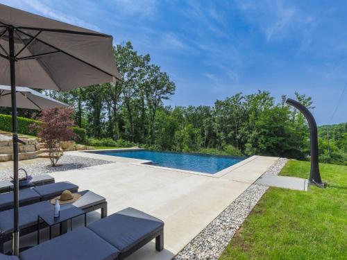 un cortile con piscina e ombrellone di Holiday Home Rokvilla by Interhome a Motovun (Montona)