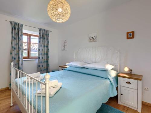 a bedroom with a white bed with a blue blanket at Holiday Home Villa Nicolara by Interhome in Buzet