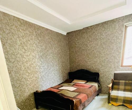 a bedroom with a bed in a room with wallpaper at Tamos home 3 in Kakhaberi