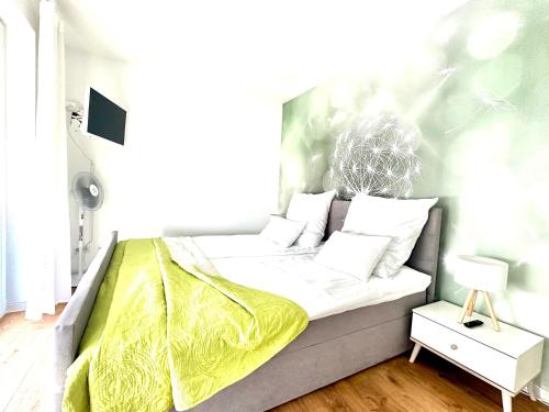 a bed with a yellow blanket on it in a room at Panorama Penthouse Apartment mit Klima und Whirlpool für bis zu 6 Personen in Frankenthal