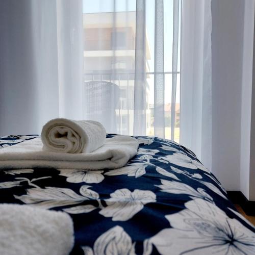 a bed with a blue and white blanket and a window at GOOD PLACE Zator in Zator