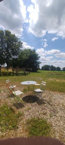 two chairs and a table in a field at Gîte de La Brenelière in Cirière