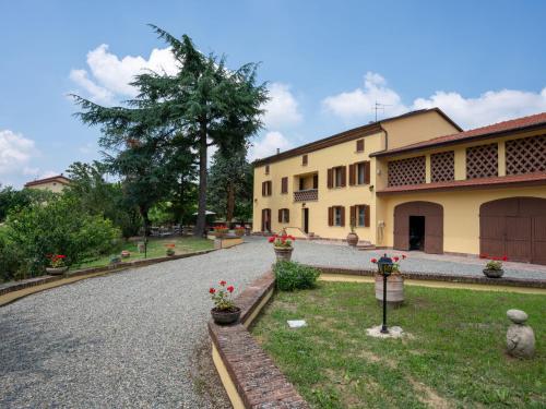 a road in front of a yellow building with flowers at Holiday Home Ca' Breia by Interhome in Castel Rocchero