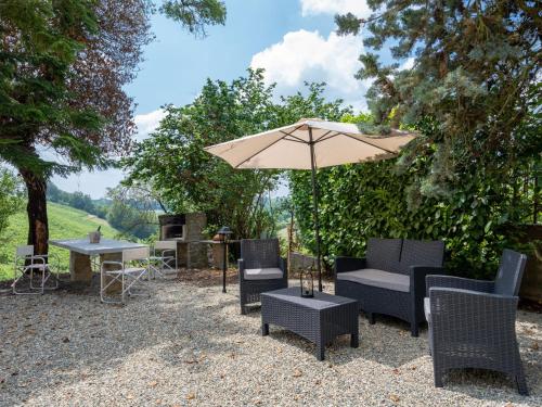 a patio with an umbrella and tables and chairs at Holiday Home Ca' Breia by Interhome in Castel Rocchero