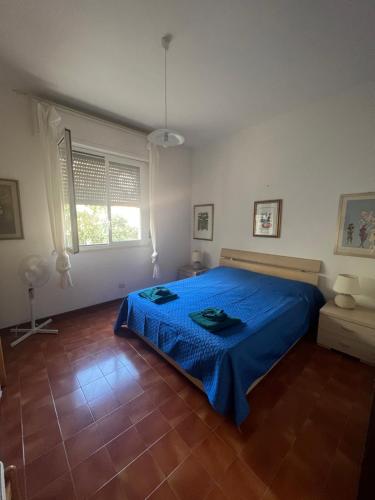 een slaapkamer met een blauw bed en een blauwe deken bij La casetta di Chloè residence con Piscina in Santa Marinella
