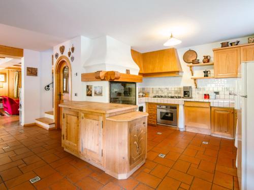 una gran cocina con armarios de madera y una gran isla en Chalet Cesa Galaldriel-3 by Interhome, en Penia